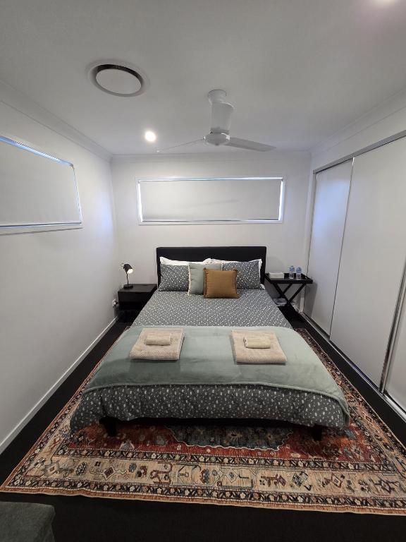 a bedroom with a large bed with a rug at Private Room with Queen Bed & Bathroom in Bellbird Park