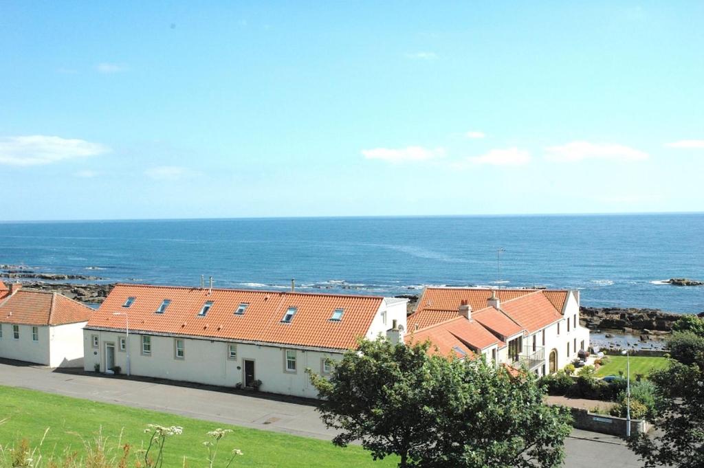a group of buildings with the ocean in the background at The Coopers View in Cellardyke