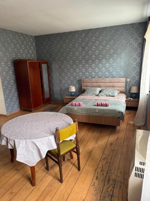a bedroom with a bed and a table and a chair at LZ Green House in Telavi