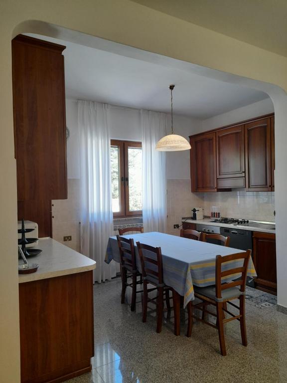 a kitchen with a table and some chairs and a table and a kitchen with at Casa da Emanuela in Drežnik Grad