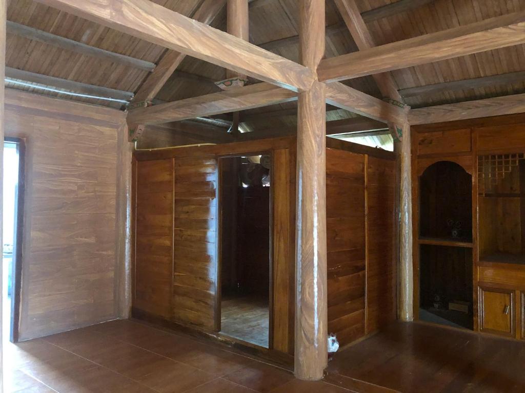an empty room with wooden walls and wooden beams at Trà My Homestay in Nhữ Khê
