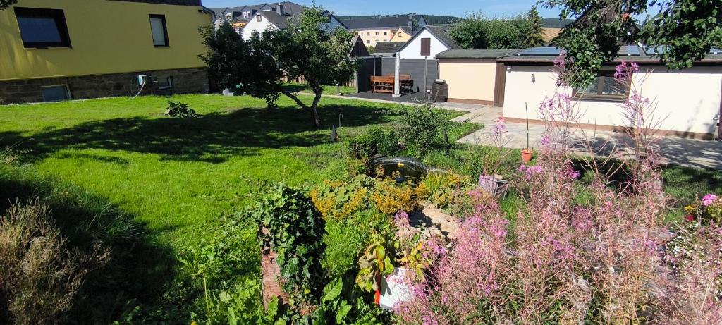 a view of a garden with flowers in a yard at Ferienhaus Erzgebirgsglück in Sehmatal