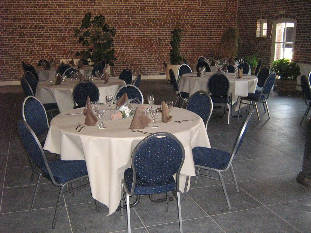 a dining room with tables and chairs in a building at Hotel Oude Eycke in Maaseik