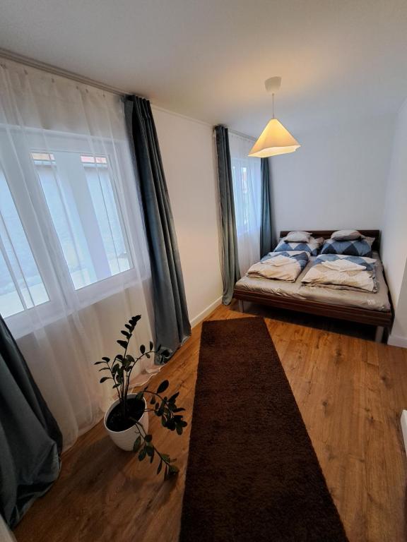 a bedroom with a bed and a large window at Most Apartmanok in Sátoraljaújhely