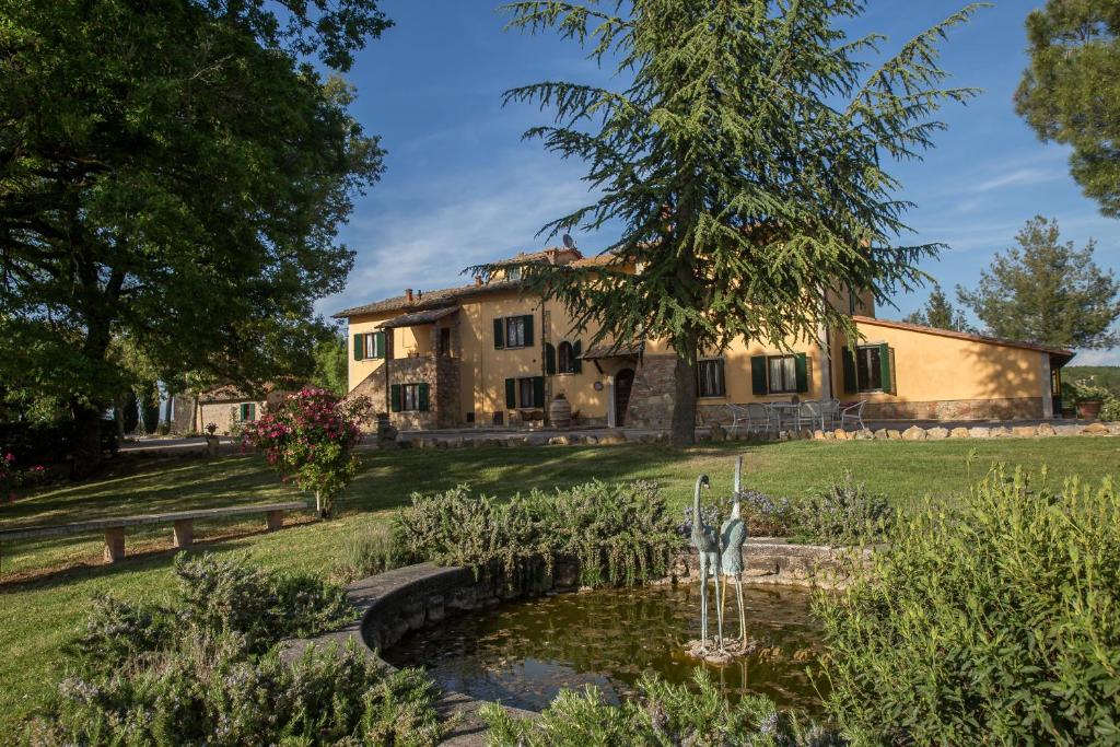 una casa con un estanque delante de ella en Agriturismo La Manonera, en Montepulciano