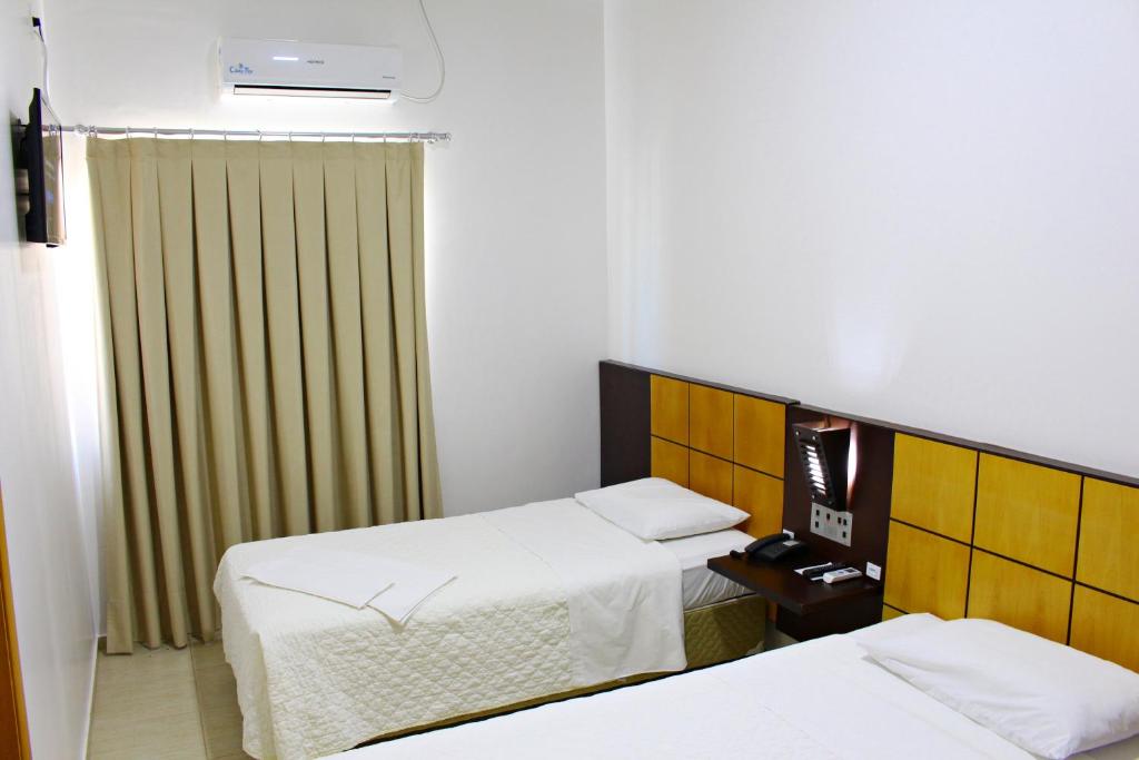 Postel nebo postele na pokoji v ubytování Dois Vizinhos Palace Hotel