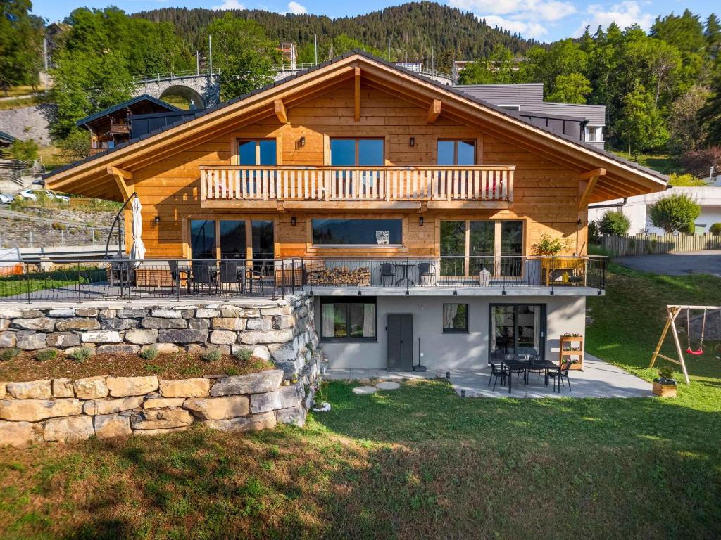 a log home with a porch and a deck at Le Petit Lu in Leysin