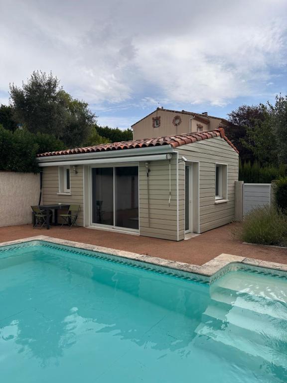 a house with a swimming pool in front of a building at Dépendance climatisée au sud de Toulouse in Lacroix-Falgarde