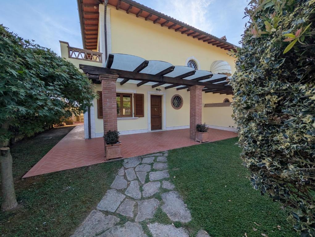 a house with a pergola in the yard at La Piccola Atene Oasi in Strettoia