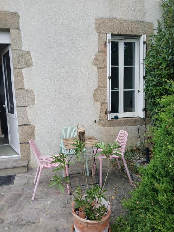 a table and two chairs sitting outside of a building at Maison proche château in Bressuire