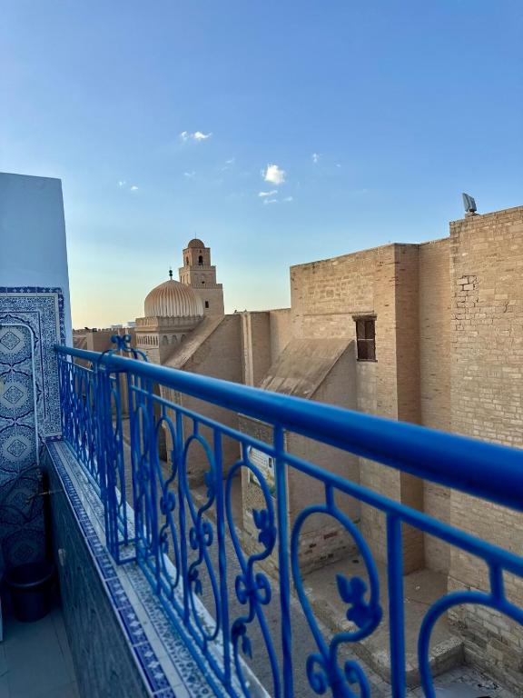 a blue railing on a balcony with a view at Le Minaret in Kairouan