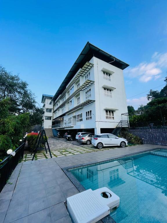 a hotel with a swimming pool in front of a building at Caravan holiday homes Vythiri in Vythiri
