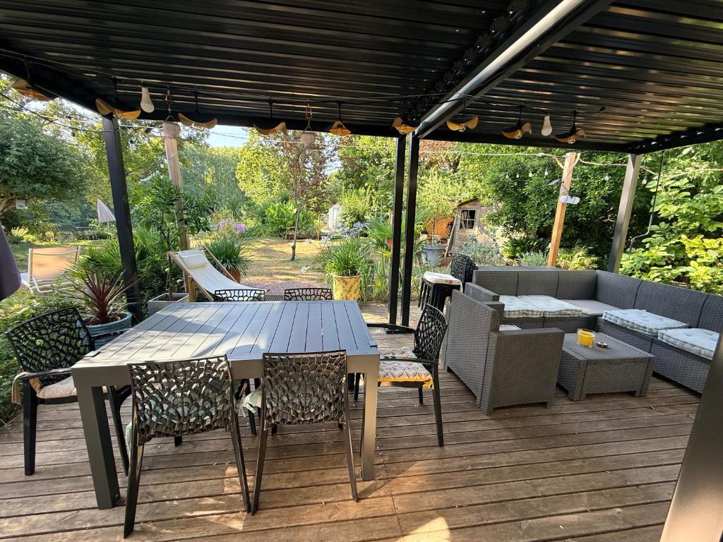 a patio with a table and chairs on a deck at Villa du Beau Port in Cenon-sur-Vienne