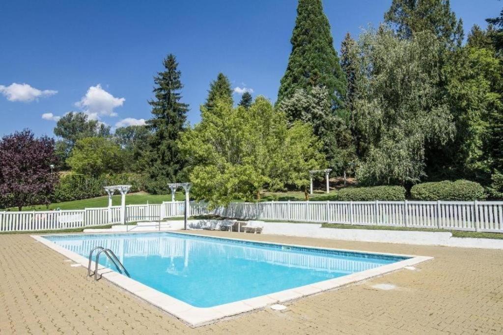 a swimming pool with a white fence and trees at Montana Family Nature in Enveitg