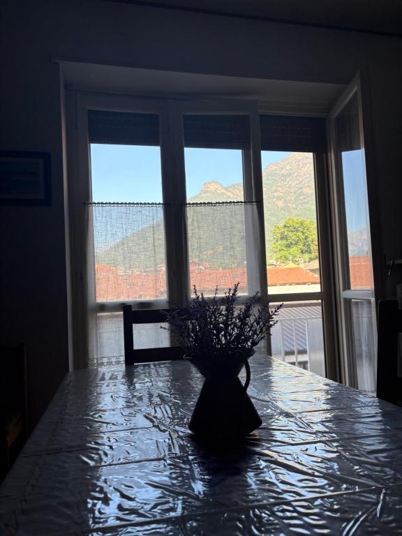 a vase on a table in front of a window at Rifugio Delia in Torre Pellice