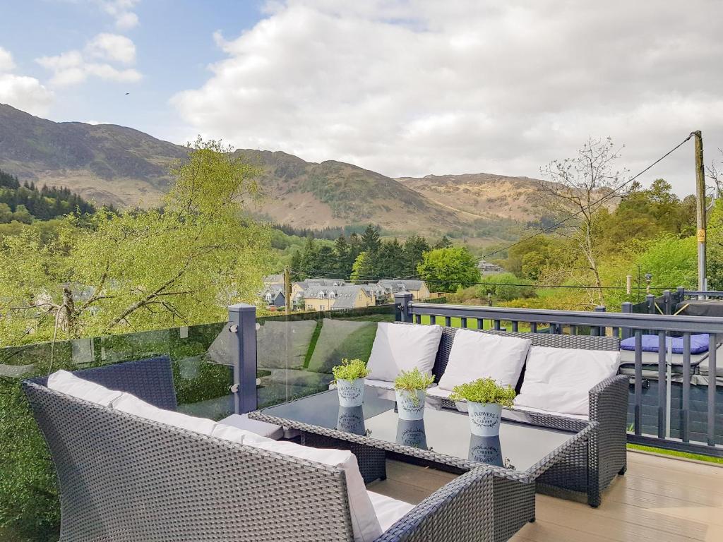 a patio with two wicker chairs and a table at Ben Vorlich Lodge in Saint Fillans