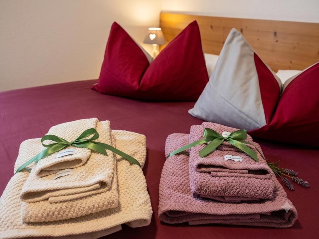 a bed with towels and pillows on it at Camere Nordest Sudest- Conca Agordina in Agordo