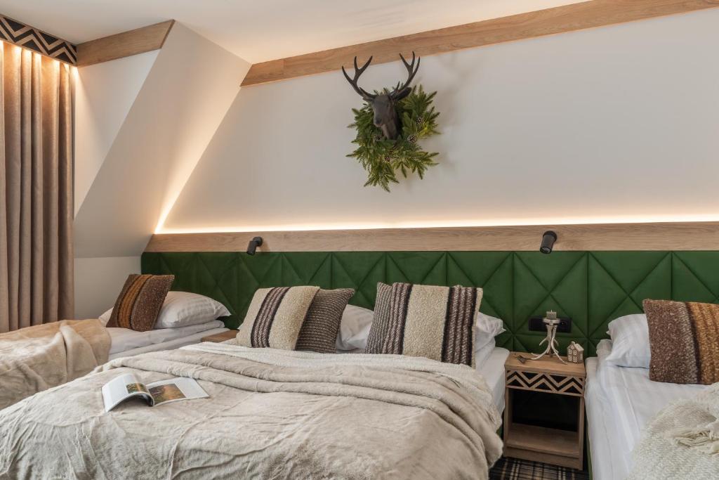 two beds in a room with a green headboard at Residence Tatrzański Park in Poronin