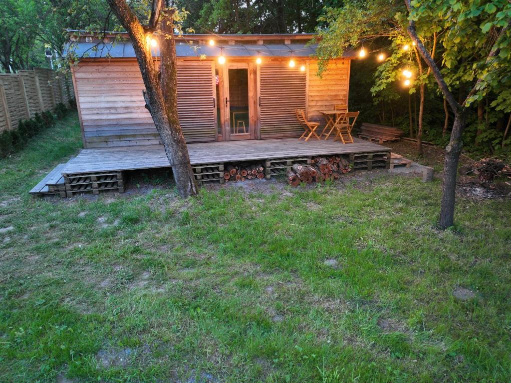 a small cabin with a deck with a table and a bench at Maringotka Bára in Huslenky