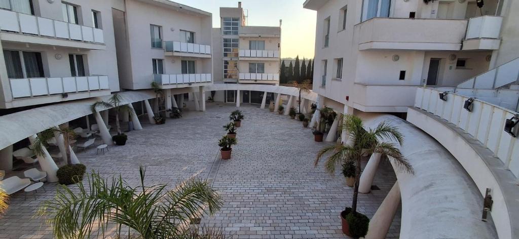 an empty hallway between two buildings with palm trees at La Corte di Leuca Residence in Leuca