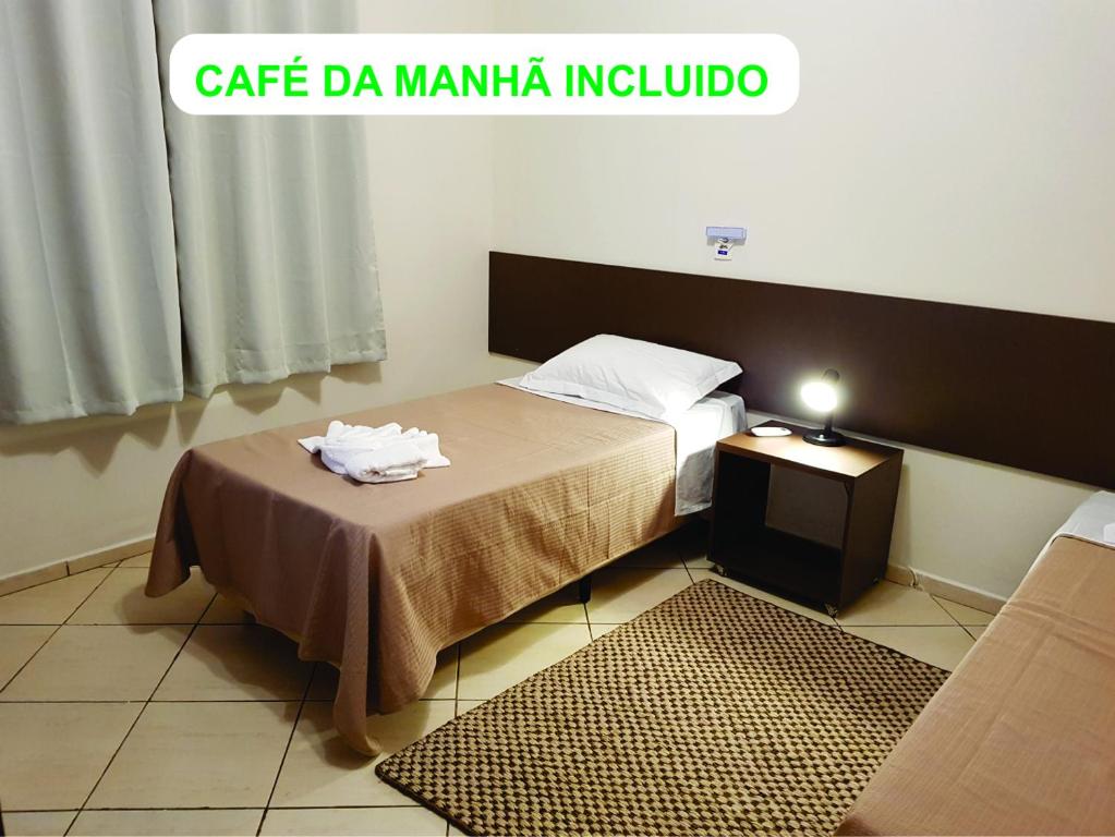 a small room with a bed and a table with towels on it at Pousada Mirante Fonte Sônia in Valinhos