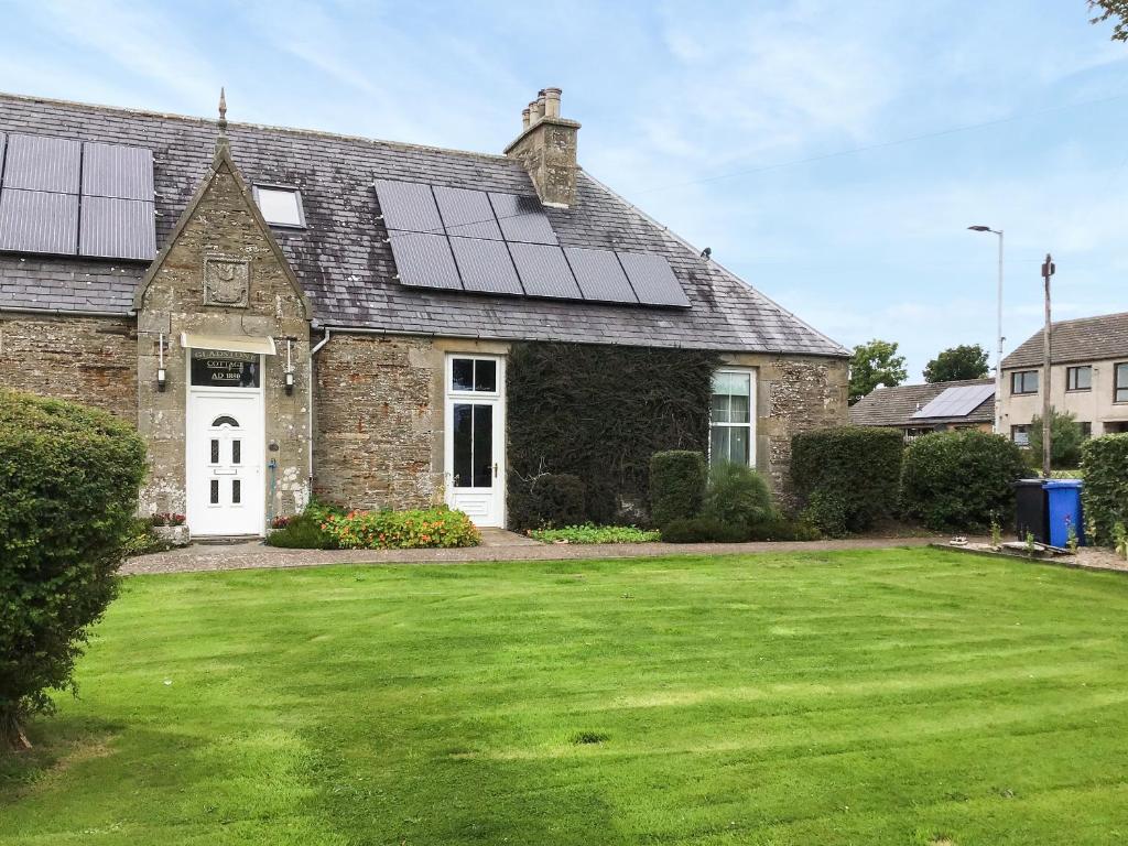 a house with solar panels on the roof at Gladstone Cottage in Castletown