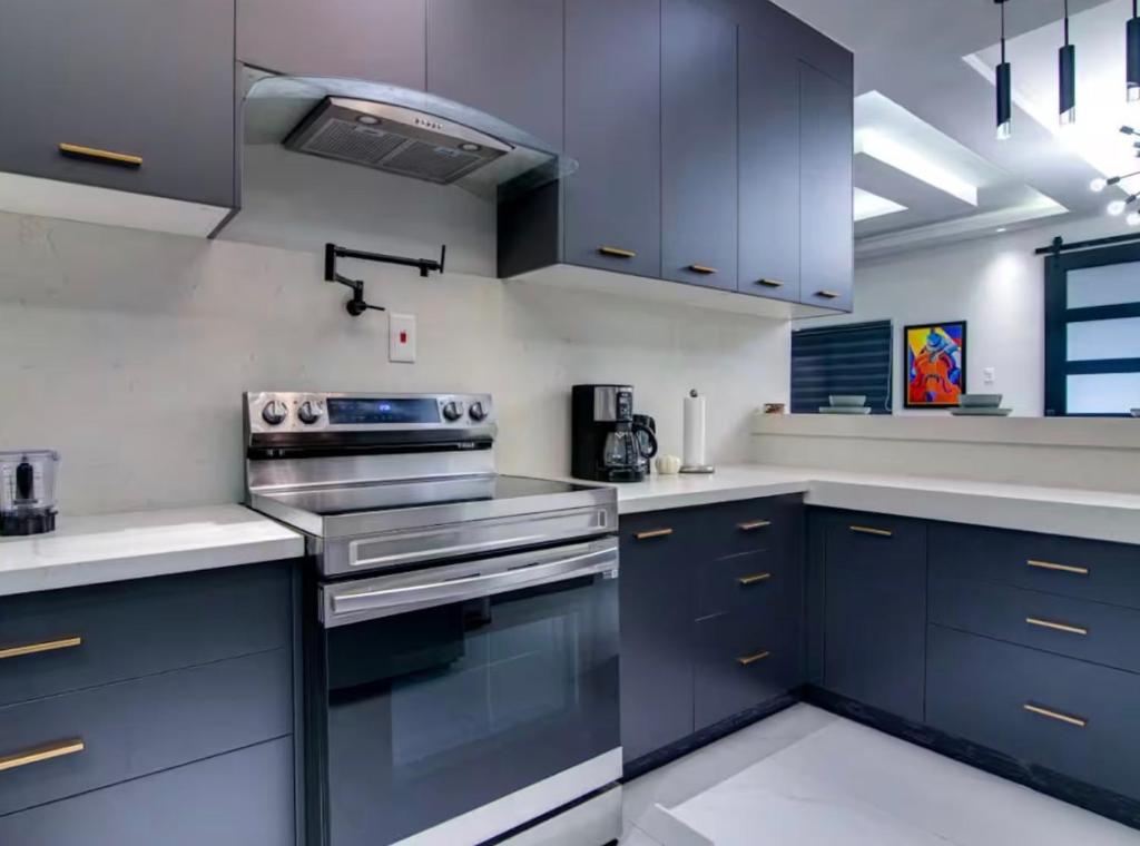 a kitchen with blue cabinets and a stove at The St Ann Haven in Seville