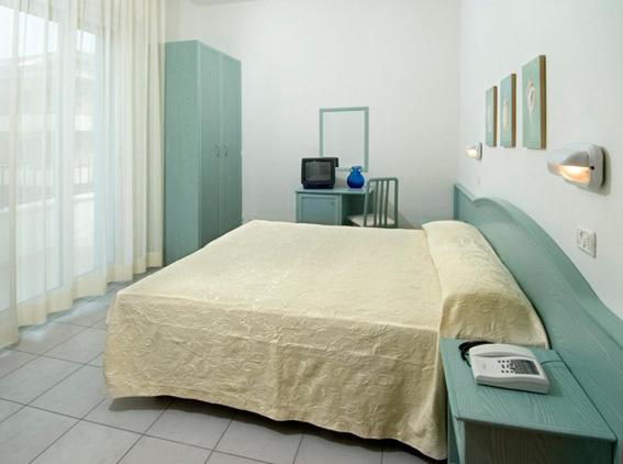a bedroom with a large bed and a television at Hotel Belmar in Cattolica