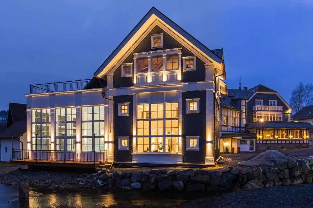 a large house with large windows at night at Lahntalhotel Feudingen in Bad Laasphe