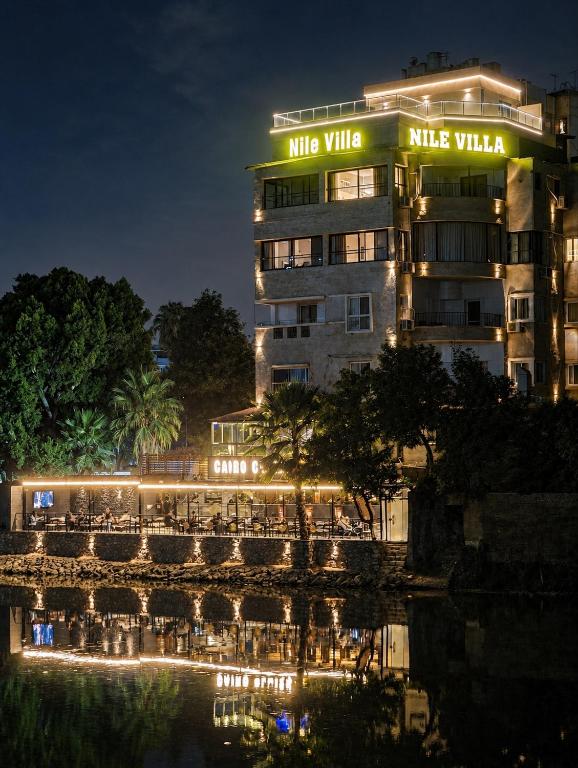 a building with a reflection in the water at night at Nile Villa Hotel in Cairo