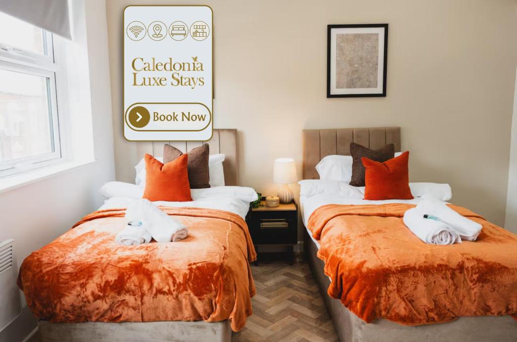 a bedroom with two beds with white towels on them at The High Town Suite in Luton