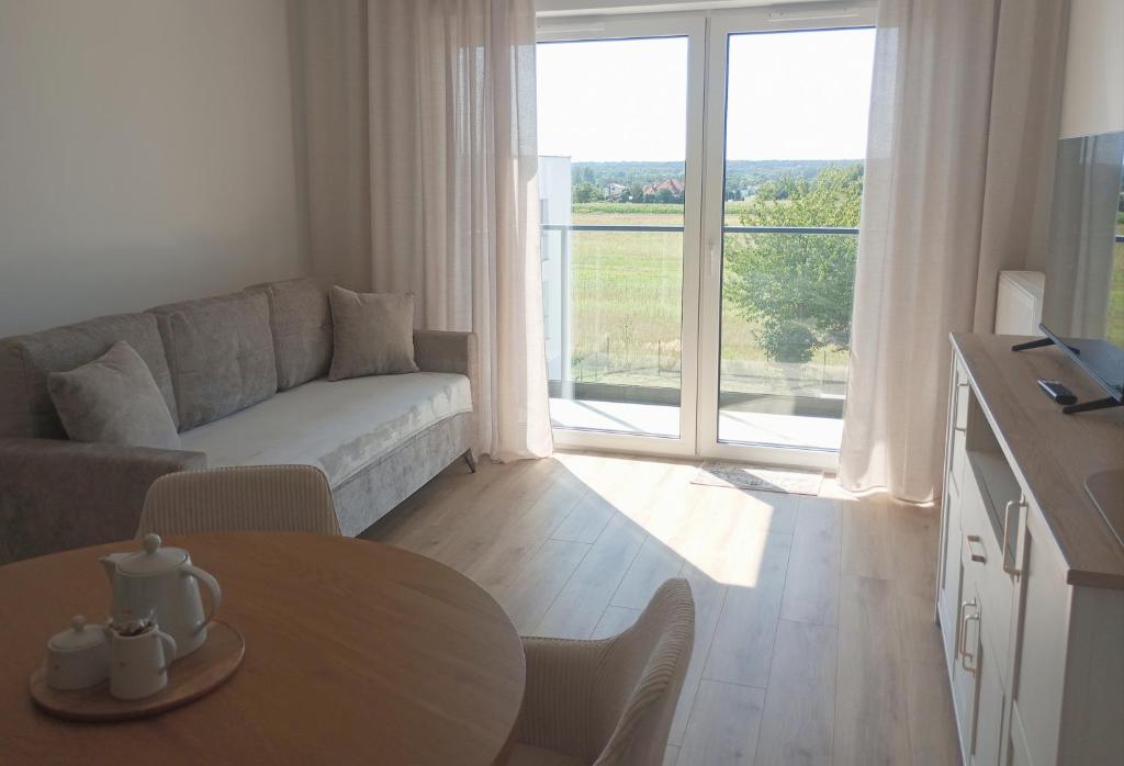 a living room with a couch and a table at Kawalerka pod lasem in Poddębice