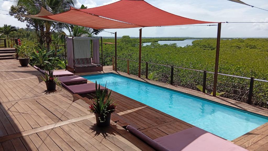 a swimming pool with chairs and an umbrella on a deck at Villa F&B 2 in Solarte