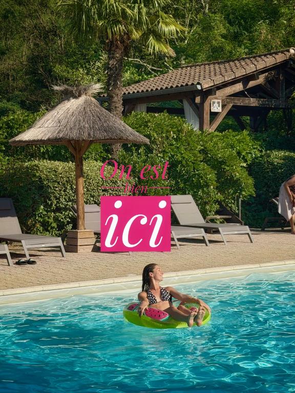 a girl sitting on a boogie board in the swimming pool at Hameau du Prat in Ribes