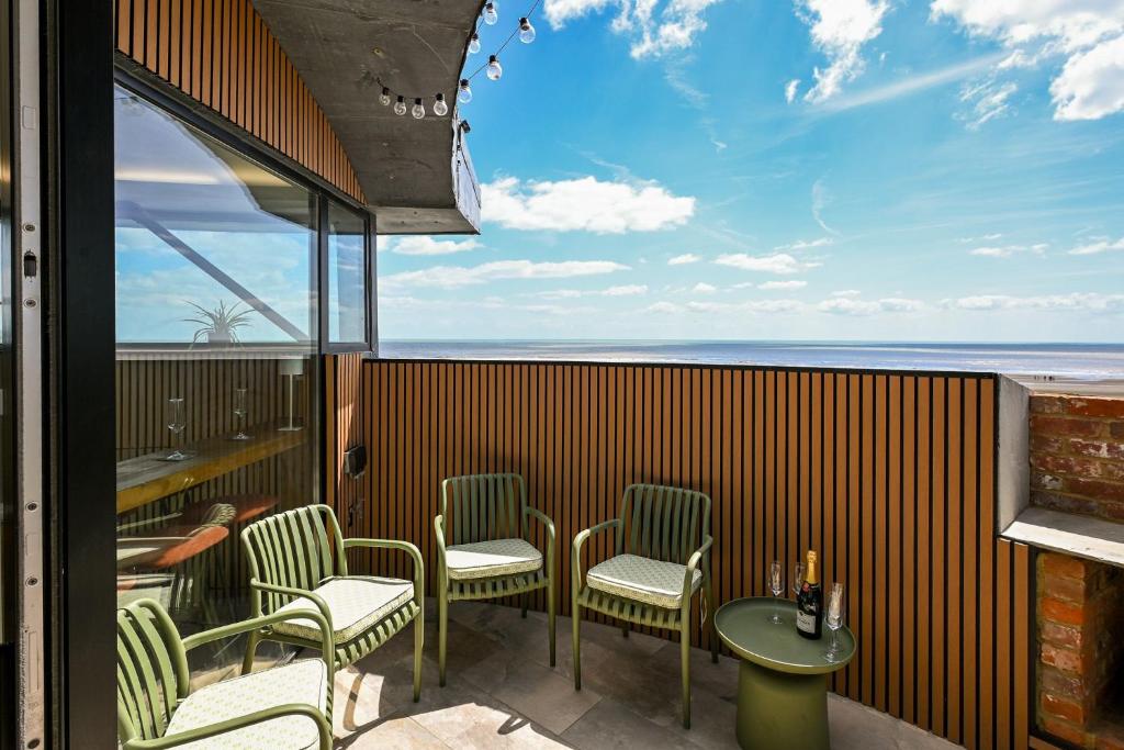 a patio with chairs and a table and a view of the ocean at Martello 25 in Dymchurch