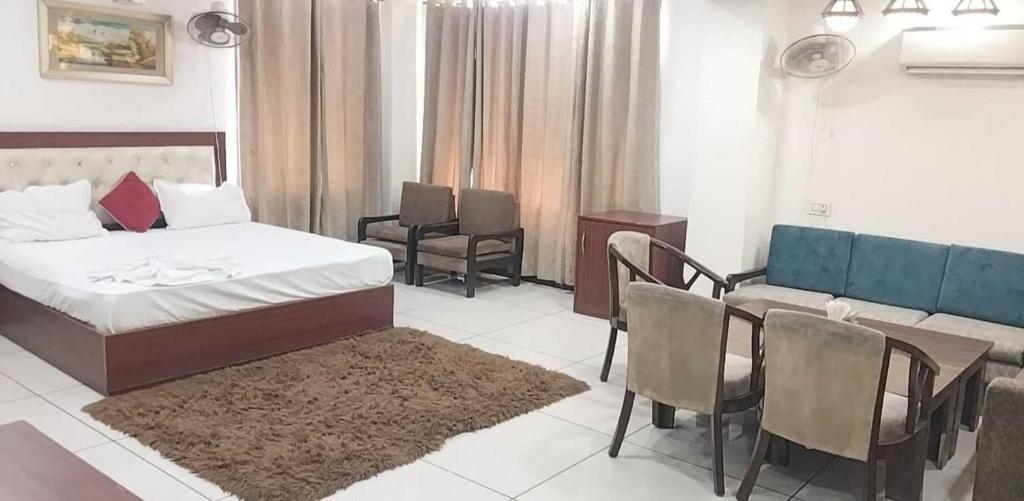 a bedroom with a bed and a table and chairs at 9 orchid Parbhat royal in Gobindgarh