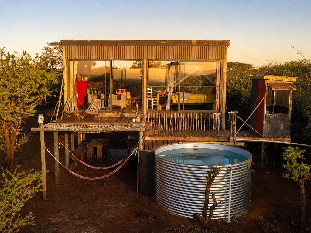 a small house with a hot tub in front of it at Mudhouse Zululand in Hluhluwe
