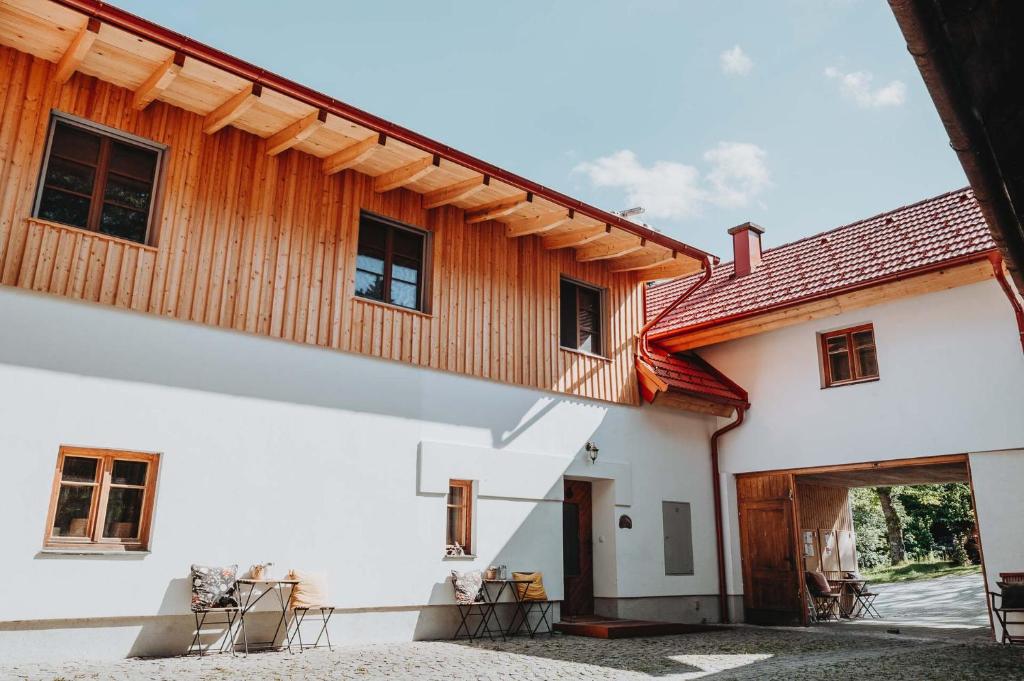 a white building with a wooden roof at Der Yogahof in Tratten