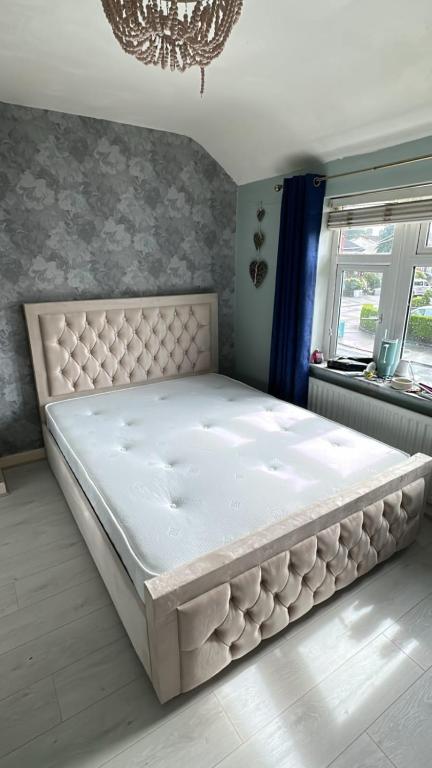 a large white bed in a bedroom with a chandelier at The Comfort Corner in Dundalk