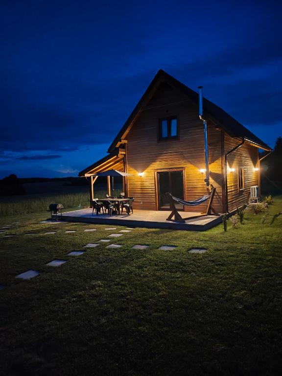 a log cabin with a playground at night at Relaks przy lesie in Idzbark
