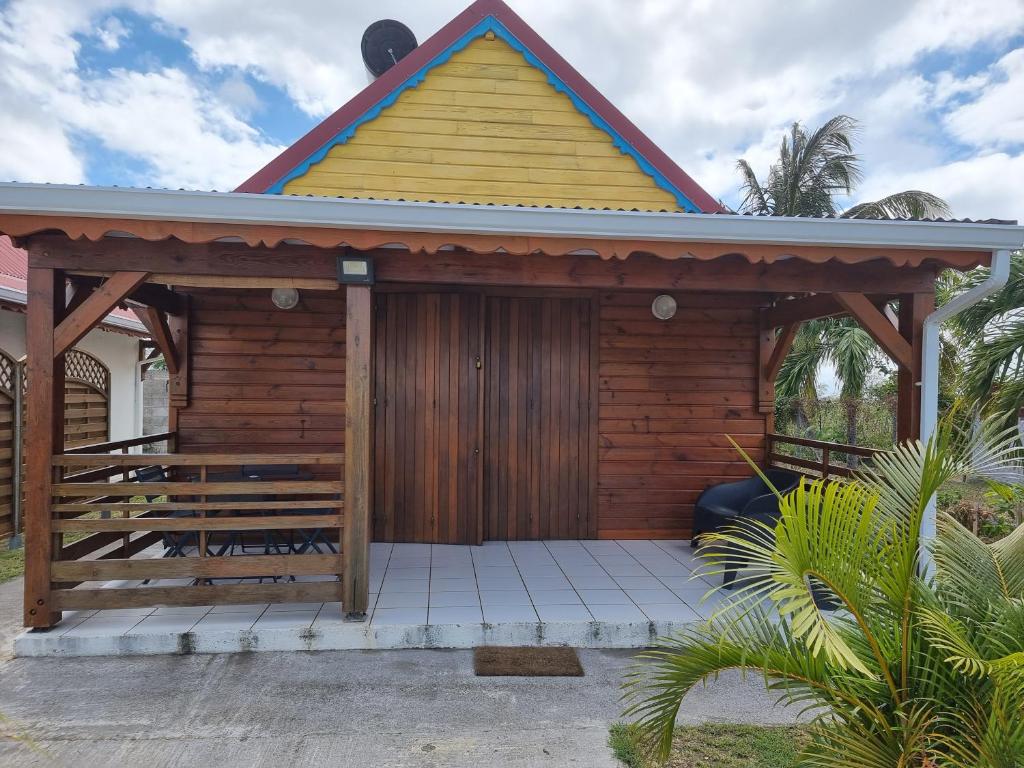 a wooden cabin with a gazebo at Résidence des Pikaniers in Anse-Bertrand