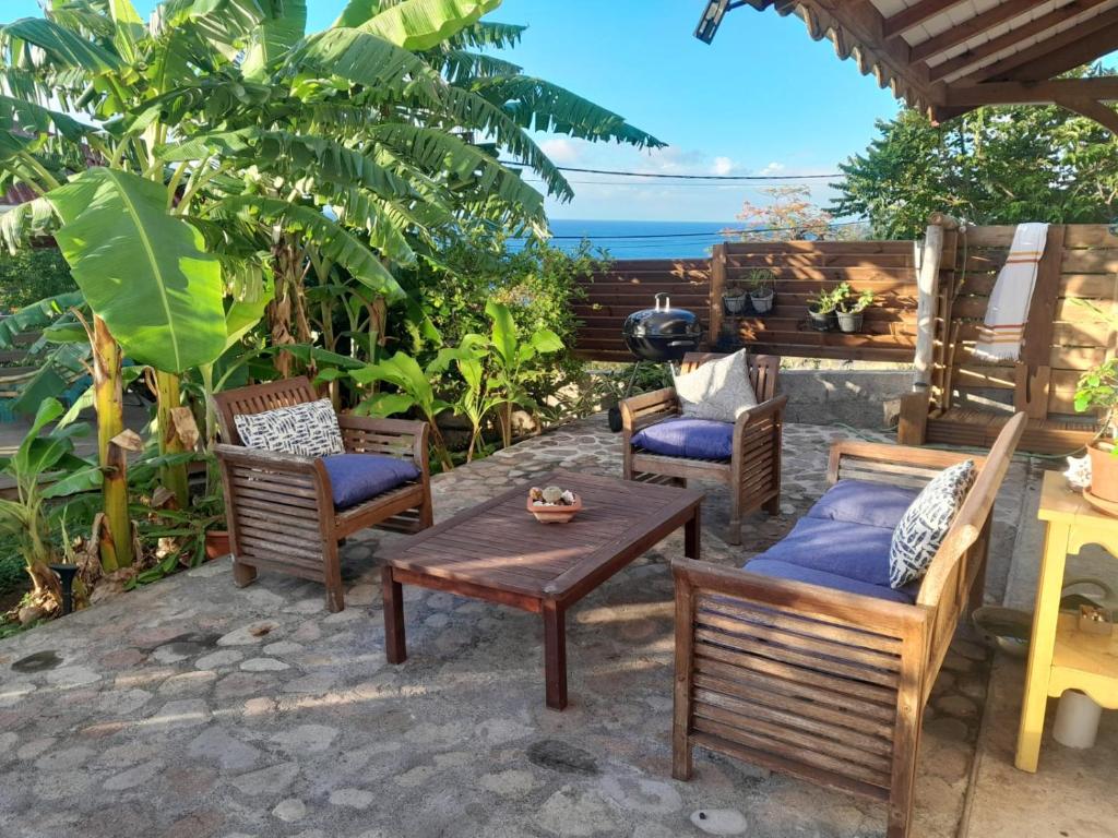 a patio with chairs and a table with a view of the ocean at Kazalou in Terre-de-Bas