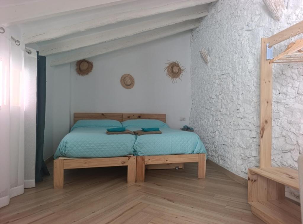 a bedroom with a bed in a stone wall at Loft B El Ramellet in Alginet