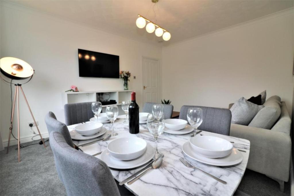 a dining room with a table with plates and wine glasses at Macintosh lower in Bellshill