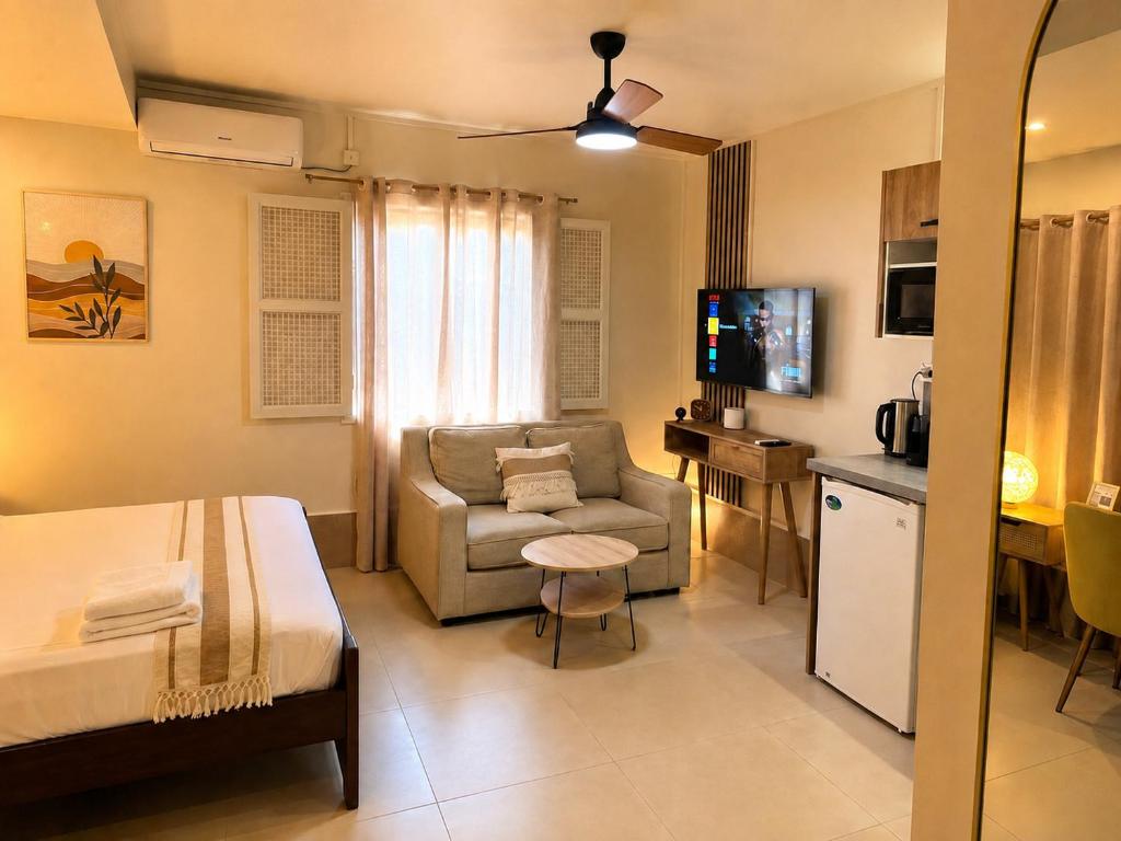 a room with a bed and a couch and a chair at Studio confort Passamainty in Mamoudzou