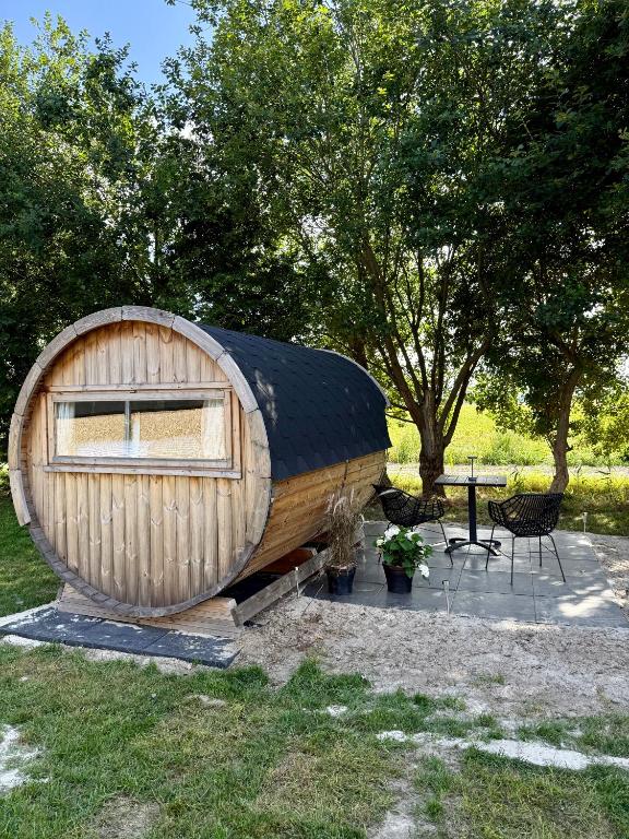 a small wooden hobbit house with a table and chairs at Barrel de Verreblik in Pieterburen