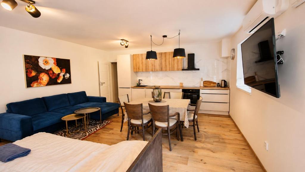 a living room with a blue couch and a table at Penzion ve dvoře in Mikulov