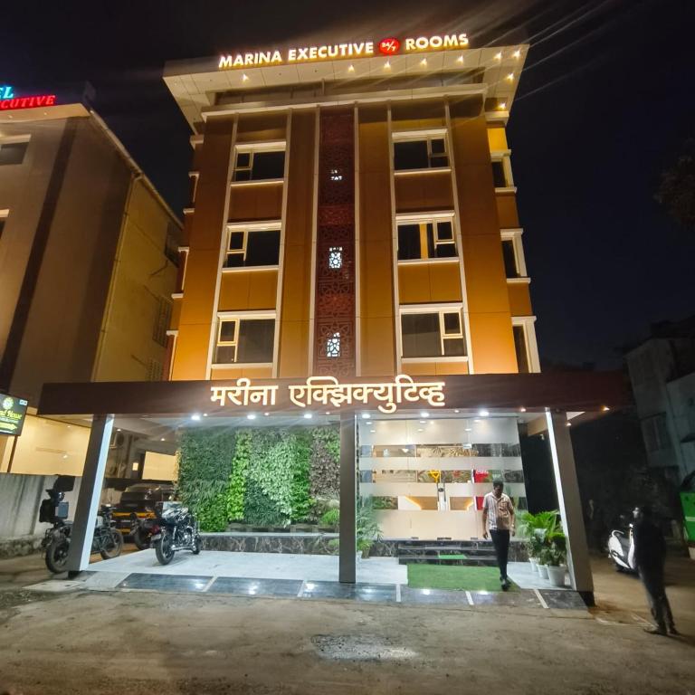 a man standing in front of a hotel at night at Marina Executive Rooms in Navi Mumbai