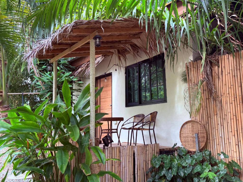 a house with two chairs and a table in front of it at Star Fish Cozy House in Ban Nua