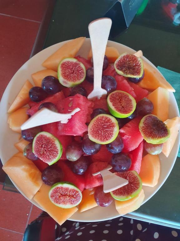 a bowl of fruit with slices of figs and other fruits at Sunset View Apartments in Bar